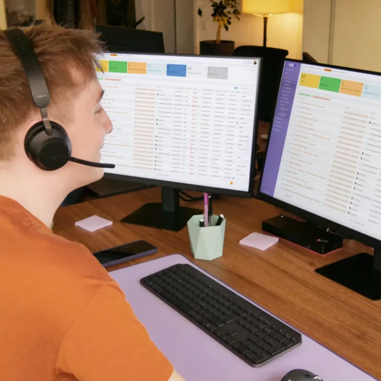 Mann mit Headset telefoniert und nimmt das Anliegen des Kunden ins Ticketsystem auf.